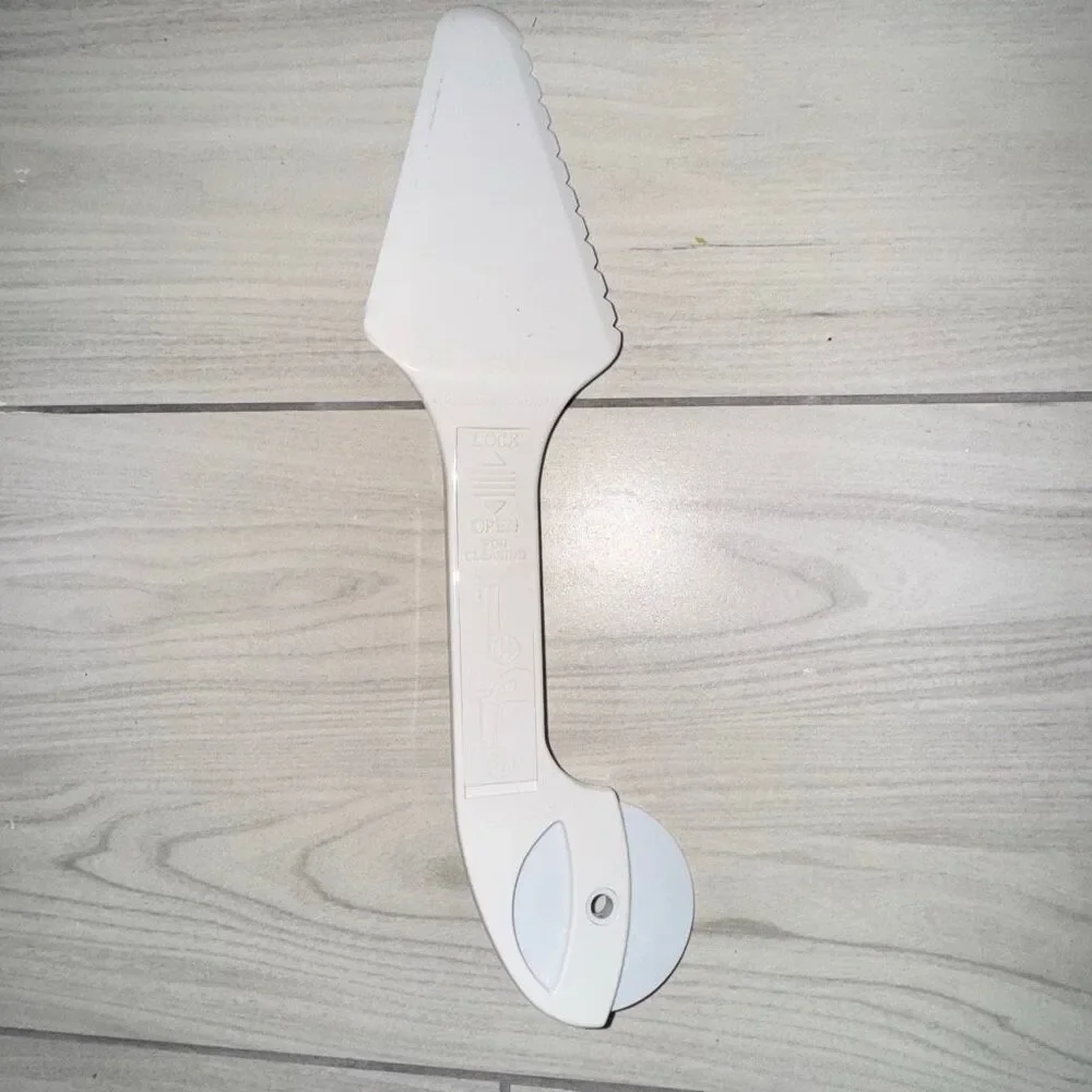 Vintage pizza cutter, cake cutter. Has a switch to push slice off and can be tak